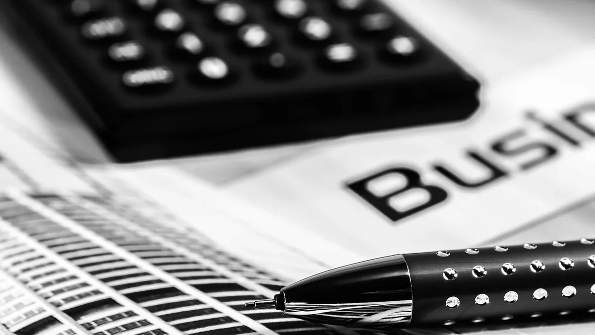A pen, a calculator, and a business document.
